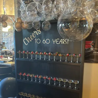 Champagne wall cheers to 60 years, lined with champagne glasses with strawberries